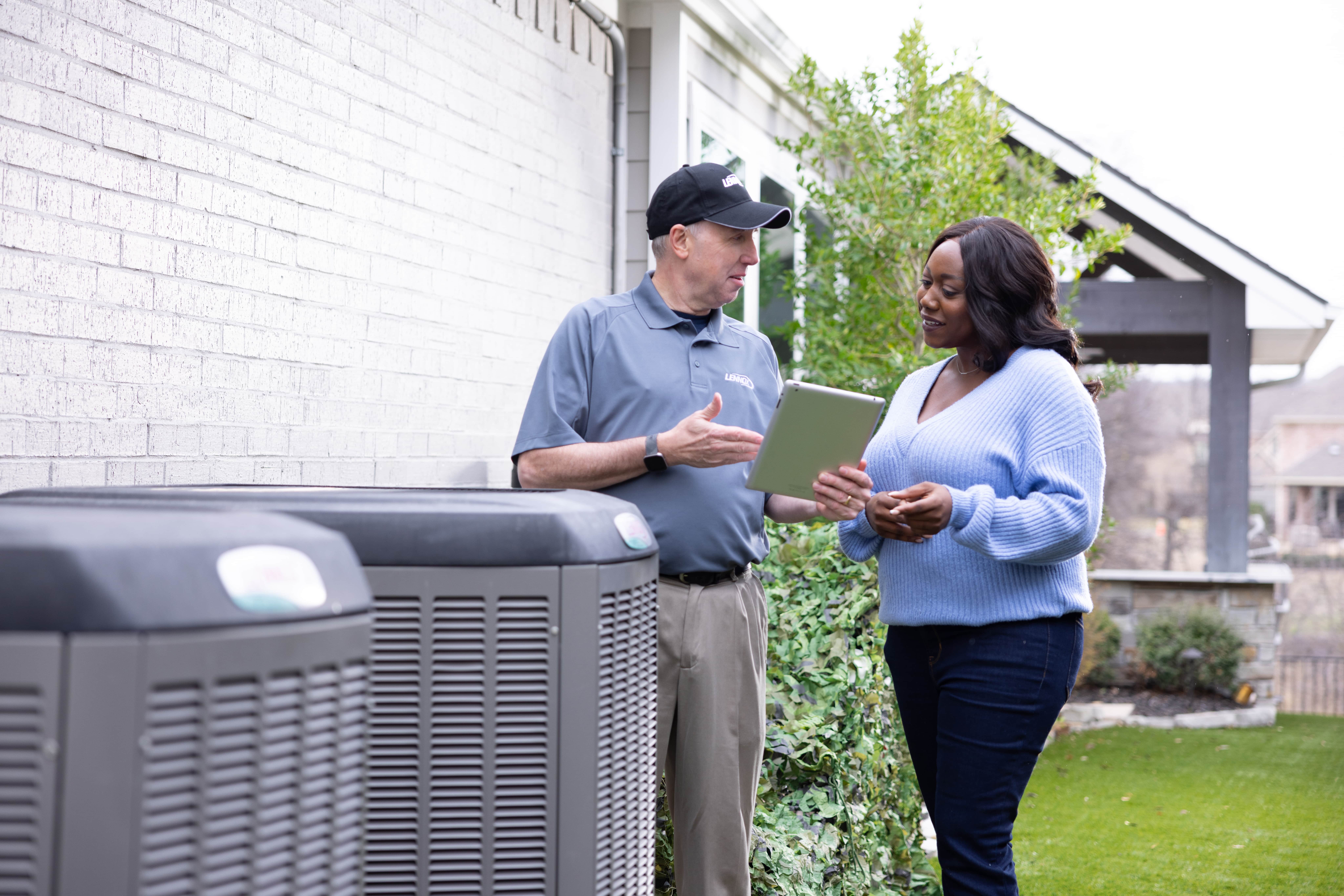 Service worker conversion with homeowner outside near A/C units